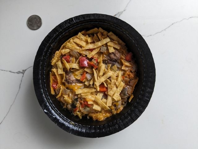 Moe's Southwest Grill Beef Tortilla Bowl Frozen Meal top-down view with quarter for comparison.